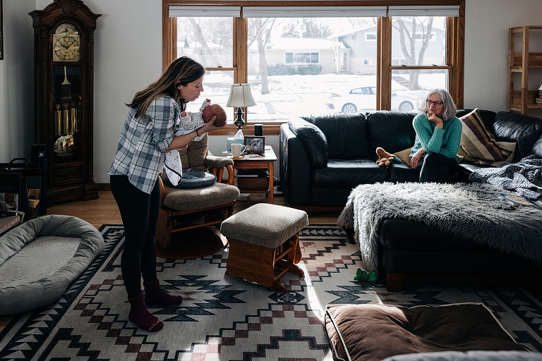 Mother gently shushes crying newborn on a winter's day in the home