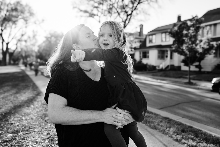 mother kisses daughter in beautiful autumn light 