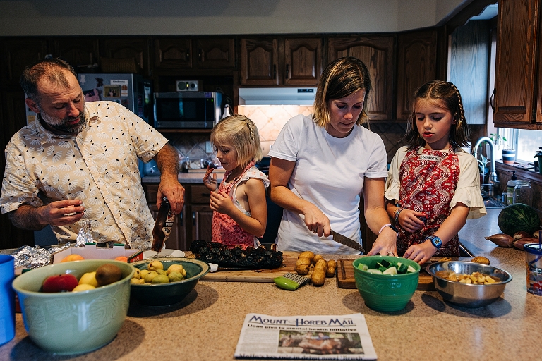 Family works together to assemble dinner on a late summer night