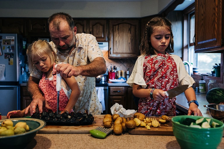 Dad assists young daughters in separating ribs with knife