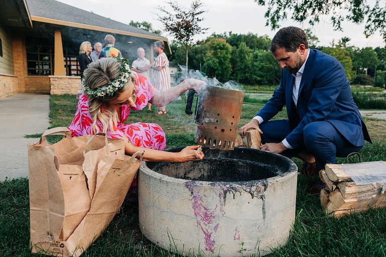 Wife and man prepare fire pit for evening activities at Tenney Park Documentary Wedding reception 