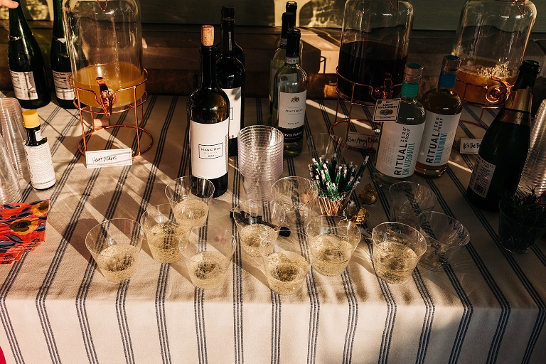 A wide selection of white wine bottles and filled glasses on the table 