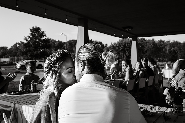 Black and white: Husband and wife share a kiss at Tenney Park Documentary Wedding reception 