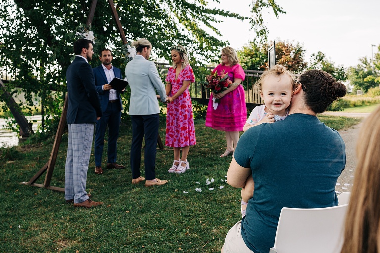 Alternate angle of Tenney Park Documentary Wedding shows toddler's smiling face in the foreground