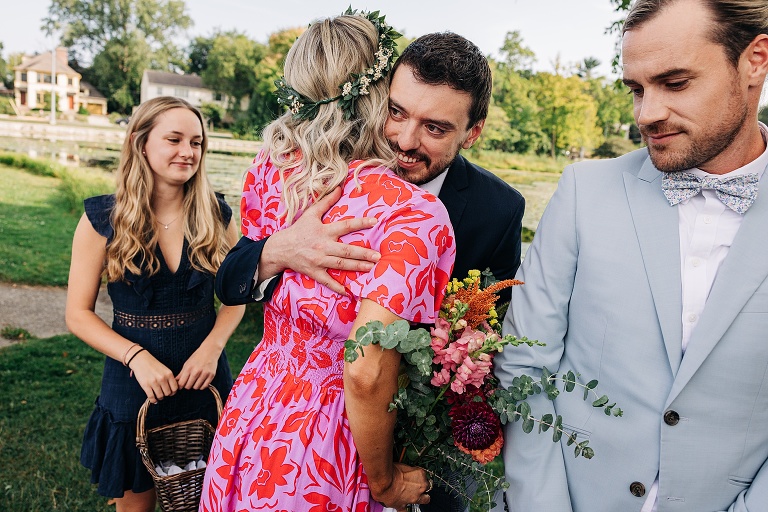 Bride embraces man with flower girl and groom also pictured