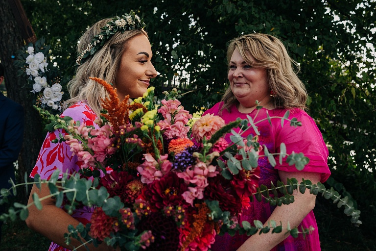 Bride receives colorful flowers from woman at Tenney Park Documentary Wedding