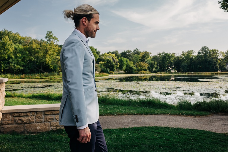 Groom walks out to ceremony with the pond at Tenney park in the background