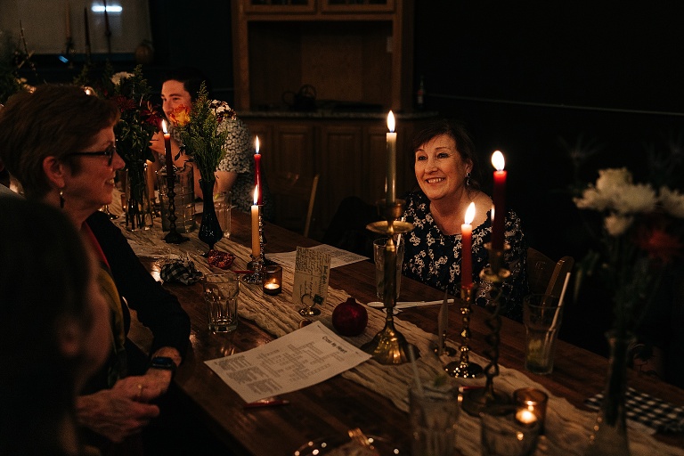 Guests converse after dinner, love themed crossword puzzles are included next to lit candles