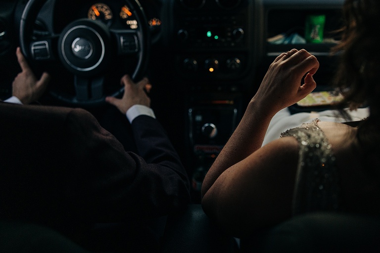 Husband drives Jeep with wife in the passenger seat, both remain in their wedding clothes