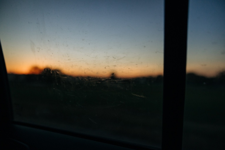 The sun sets through a dirty car window after Fall Wedding At Home