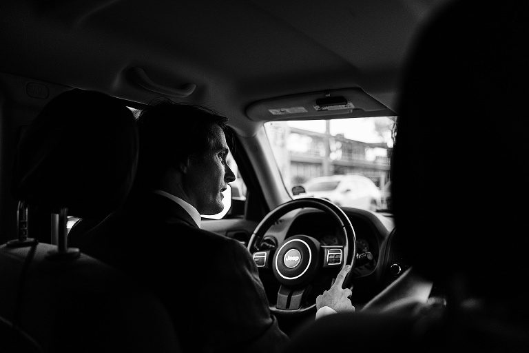 Black and white: husband drives wife in a Jeep, photo taken from behind the passenger seat