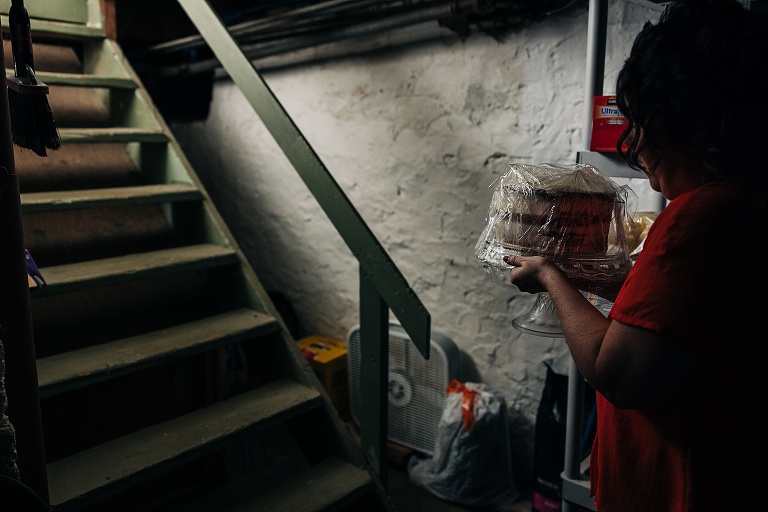 Woman brings cake upstairs from the basement for the fall wedding at home