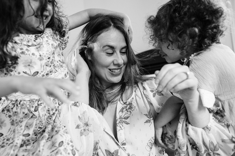 mom stays stationary as her children joyfully run around her